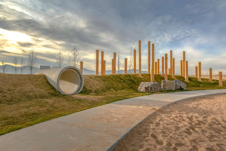 Pathway along slope with concrete pipe and polesの写真素材