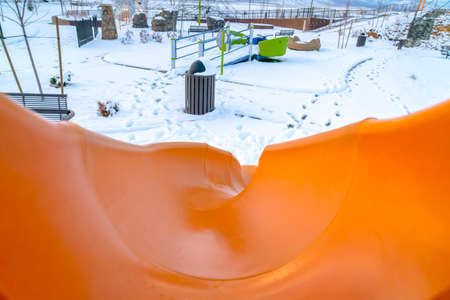 Orange slide on snowy playground in Eagle Mountainの写真素材