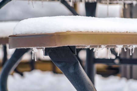 Outdoor bench topped with a thick layer of snowの写真素材