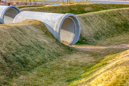 Playground with concrete pipes on grassy slopesの写真素材