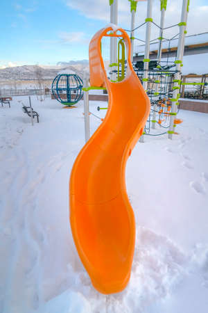 Slide and climbing frame on a snowy playgroundの写真素材