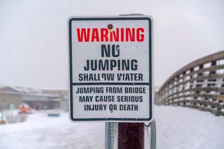 Warning sign on bridge over lake in Daybreak Utahの写真素材