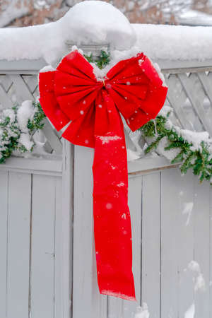 White fence with vibrant red ribbon and garlandの写真素材