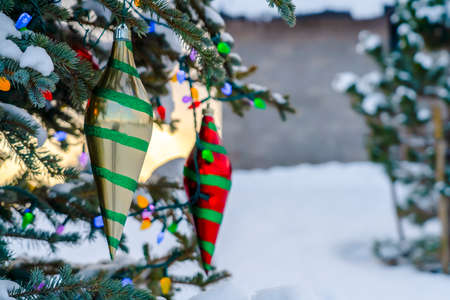 Tree with colorful decoration against snowy groundの写真素材