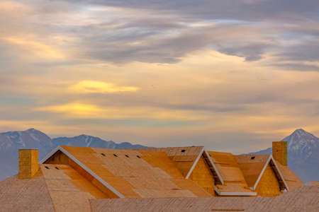Unfinished roof with mountain and cloudy sky viewの写真素材