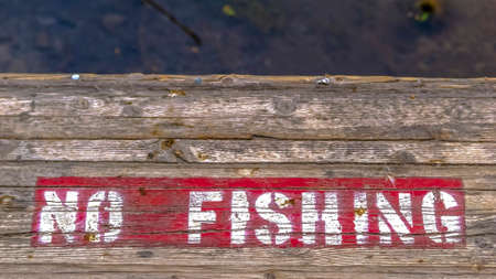 Wooden platform with painted No Fishing signの写真素材