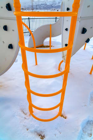 Ladder of playground climber against snowy groundの写真素材