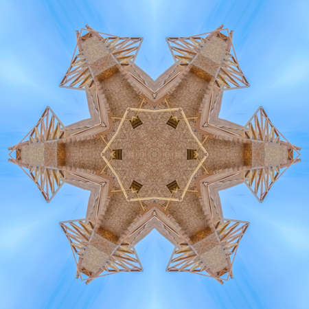 Complex wooden shape made from construction. Geometric kaleidoscope pattern on mirrored axis of...