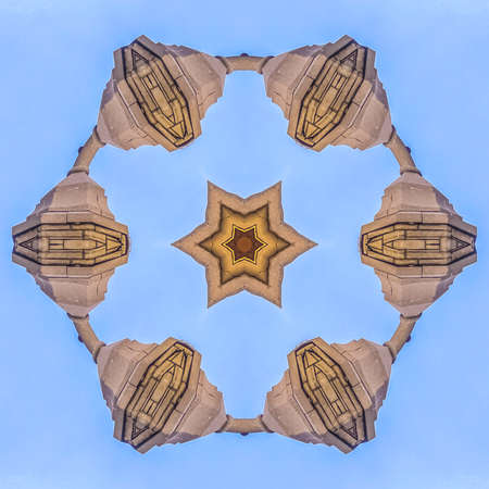 Star fractal made from photo of church steeple. Geometric kaleidoscope pattern on mirrored axis of...
