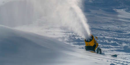 Snow cannon spraying artificial snow in winterの写真素材