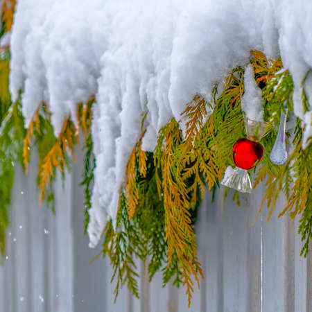 Snow covered garland on a wooden fence in Daybreakの写真素材