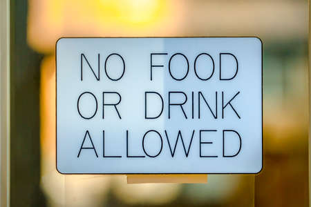 No Food Or Drink Allowed on a glass surface. Close up view of a No Food Or Drink Allowed against a glass surface of an establishment. It prohibits people from eating or drinking inside the premises.の写真素材