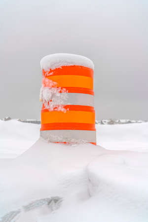 Bright traffic post half buried in fresh snowの写真素材