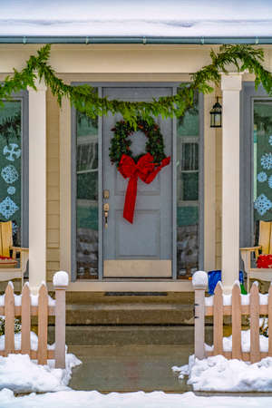 Entrance of snowy home with holiday decorationsの写真素材