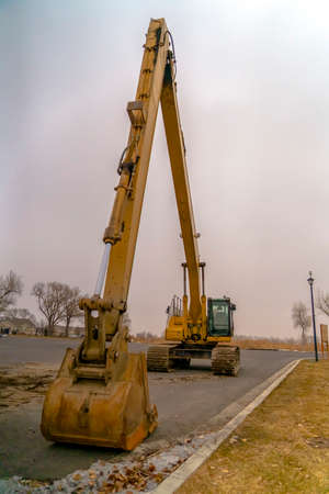 Excavator on the road with sky in the backgroundの写真素材