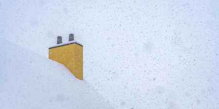 Snowy roof and chimney against sky in Daybreakの写真素材