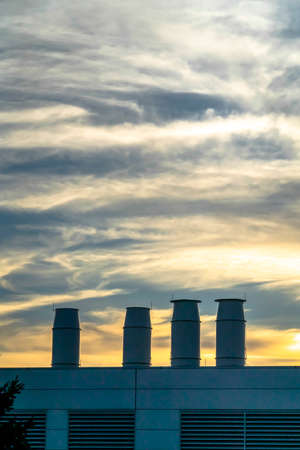 A Building with smokestacks against dramatic sky