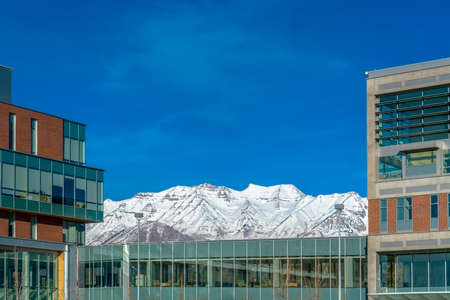 Building against snowy mountain and vibrant skyの写真素材