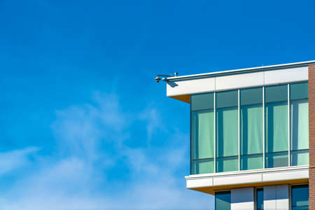Building exterior with security camera against sky
