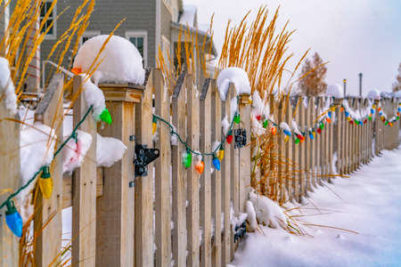 Colorful lights on snowy wooden gate and fenceの写真素材