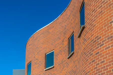 Curvy brick building exterior against blue skyの写真素材