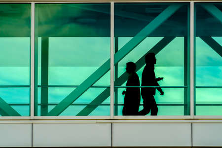 Silhouette of people seen through glass windows