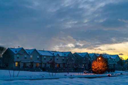 Snowy homes in Eagle Mountain Utah at twilight. Homes in Eagle Mountain, Utah against cloudy sky at twilight. Snow blankets the roofs and ground on this frosty winter day in December.の写真素材
