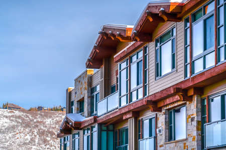 Building against snowy mountain and blue sky. Exterior of a beautiful building with sunlight...