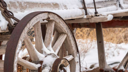 Clear Panorama An old wooden wagon with rusty wheels dusted with snow in winter