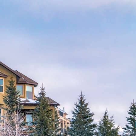 Square Exterior of an elegant house against blue sky with puffy clouds in winter