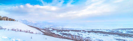 Panoramic view of a stunning snowy mountain against vibrant sky with cloudsの写真素材