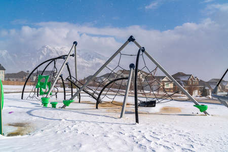 Climbing frames on a playground blanketed with snow on a sunny winter dayの写真素材