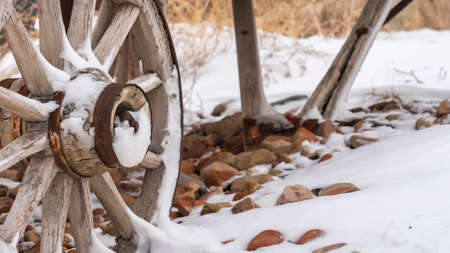Panorama An old wooden wagon with rusty wheels dusted with snow in winterの写真素材