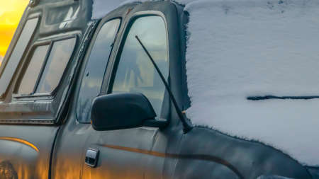 Clear Panorama Snow covered black vehicle with a car top carrier mounted on the roof rackの写真素材