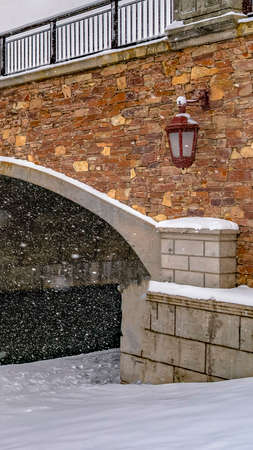 Clear Vertical Bridge over the rippling water of Oquirrh Lake with snowy white shore. A stunning winter landscape with view of residential houses in the distance.の写真素材