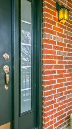 Vertical Front porch of a home with table and chairs in front of brick wall and window. The outdoor...