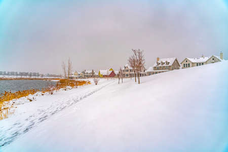 Scenic snowy lake landscape in Daybreak Utah. A stunning and scenic snow covered landscape by the Oquirrh Lake in Daybreak, Utah during winter season with view of homes and buildings in the distance.の写真素材