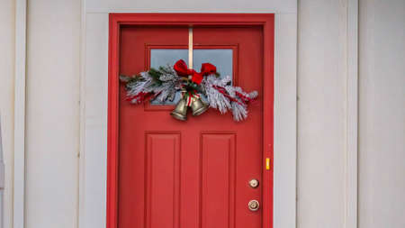 Clear Panorama Front door with glass panel and holiday decoration against a ribbed white wall....