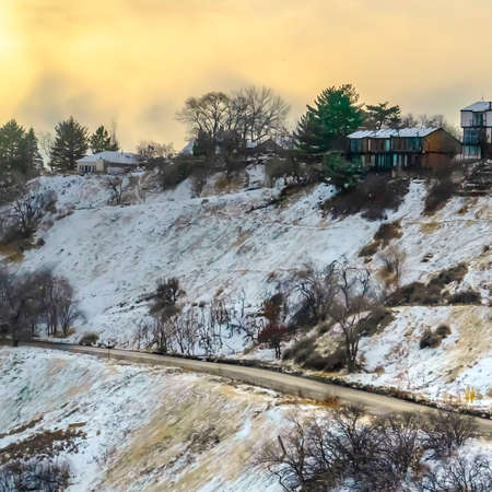 Square Snowy hill in Salt Lake City with road and homes. A hill in Salt Lake City, Utah covered with snow in winter. Scenic landscape with road and homes on the snowy hill viewed at sunset.の写真素材
