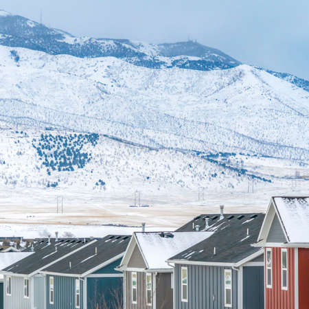 Square Colorful houses against a breathtaking snow coated landscape in winter. The homes have a view...