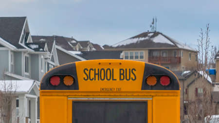 Clear Panorama Rear view of a yellow school bus with a window and several signal lights. The bus...