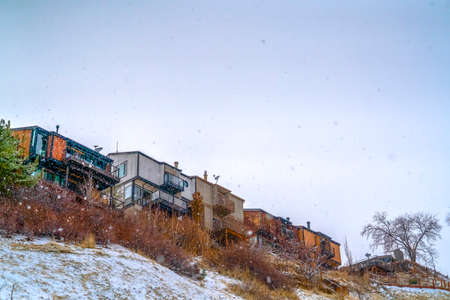 Snowy hill with houses in Salt Lake City Utah. Snow covered hill in Salt Lake City, Utah viewed in winter. Houses can be seen on top of the frosty hill with vast bright sky in the background.の写真素材