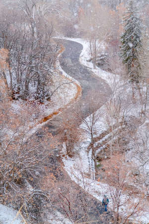 Mountain road on a snowy winter day in Utah. Aerial view of a road curving through a mountain in Salt Lake City. Mountain with road landscape blanketed with snow on a frosty winter day.の写真素材