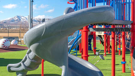 Clear Panorama Spiral slide on a colorful playground against a vibrant lawn on a sunny day. The play...