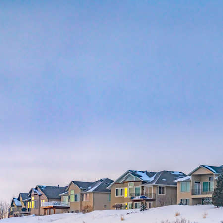 Square Residences built on a frosted mountain overlooking a vast sky with cloudsの写真素材