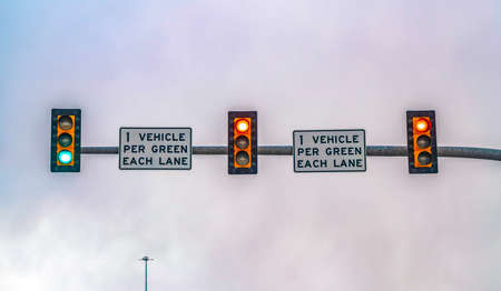 Traffic lights on a metal pole isolated against cloudy sky background