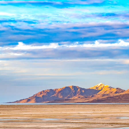 Square Vast sandy shore of a lake under bright blue sky with thick puffy cloudsの写真素材
