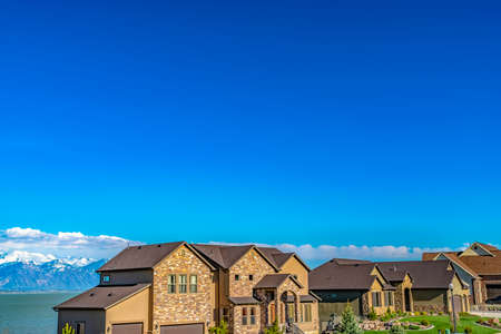 Facade of elegant homes with beautifully landscaped lawns viewed on a sunny day