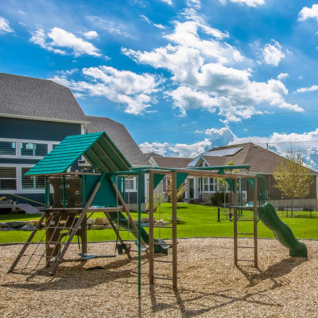 Frame Square Playground on a rich green field surrounded by trees and houses