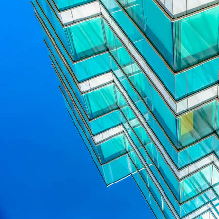Square Close up of an office building exterior against blue sky on a sunny day